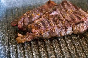 saftiges rindfleischsteak, das in der professionellen küche auf einer grillpfanne gekocht wird. Prime Steak Braten am Grill. leckere, moderne Küche. foto