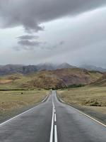 die straße führt in die ferne in den bergen, einem teil des tschuisky-trakts, altai, russland foto