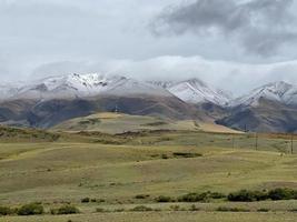 wolken, die auf den spitzen der schneebedeckten berge im altai-gebirge liegen foto