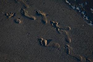 spuren im sand am strand, sandstrand, meereswellen. foto