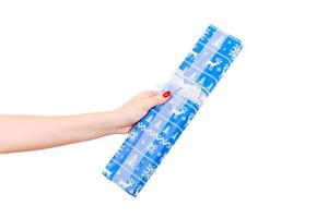 Frauenhände geben eingewickeltes Weihnachts- oder anderes handgemachtes Weihnachtsgeschenk in blauem Papier mit weißem Band. isoliert auf weißem Hintergrund, Ansicht von oben. Thanksgiving-Geschenkbox-Konzept foto