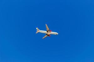 Ein Flugzeug, das am blauen Himmel ohne weiße Wolken fliegt foto