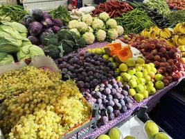 sonniger Markt. Obst und Gemüse auf dem traditionellen Markt. Die Ernte wird in Kisten verkauft. Markt mit verschiedenen bunten frischen Früchten und Gemüse foto