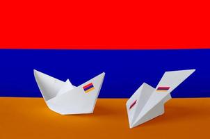 armenische flagge auf papier origami flugzeug und boot dargestellt. handgemachtes kunstkonzept foto