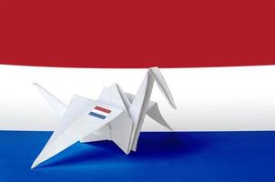 niederländische flagge auf papier origami-kranichflügel dargestellt. handgemachtes kunstkonzept foto