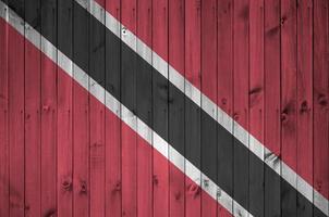 die flagge von trinidad und tobago ist in hellen farben auf einer alten holzwand dargestellt. strukturierte Fahne auf rauem Hintergrund foto