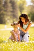 Mutter mit kleiner Tochter, die sich an einem sonnigen Tag im Park amüsiert