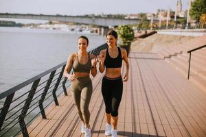 junge Frau beim Lauftraining an der Flusspromenade foto