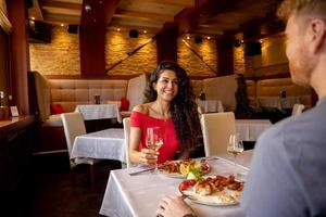 junges Paar beim Mittagessen mit Weißwein im Restaurant foto