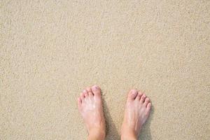 Nahaufnahme der nackten Füße eines Mannes stehen nass am Strand foto