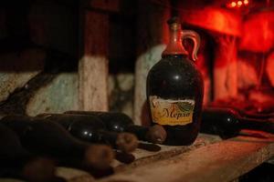 Flaschen Wein in einem alten Keller mit Spinnweben foto
