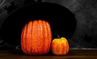 Halloween-Hintergrund mit Kürbis mit Hexenhut vor dunklem Hintergrund. Banner in den Farben Schwarz und Orange. foto