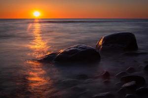 Steine an der Küste der Ostsee bei Sonnenuntergang foto