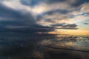 Ostseeküste mit Kieselsteinen und Eis bei Sonnenuntergang foto