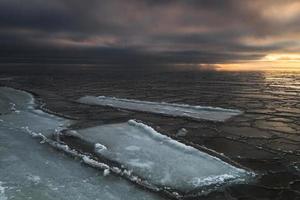 Ostseeküste mit Kieselsteinen und Eis bei Sonnenuntergang foto