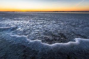 Ostseeküste mit Kieselsteinen und Eis bei Sonnenuntergang foto