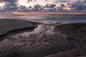 Ostseeküste mit Kieselsteinen und Eis bei Sonnenuntergang foto