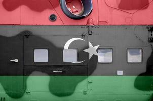 Libyen-Flagge auf der Seite des militärischen Panzerhubschraubers in der Nähe abgebildet. konzeptioneller hintergrund der armeeflugzeuge foto