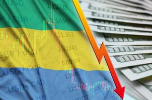 Gabun-Flagge und Diagramm fallende US-Dollar-Position mit einem Fan von Dollarnoten foto