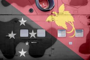 papua-neuguinea-flagge, die auf dem seitenteil des militärischen gepanzerten hubschraubers in der nähe abgebildet ist. konzeptioneller hintergrund der armeeflugzeuge foto