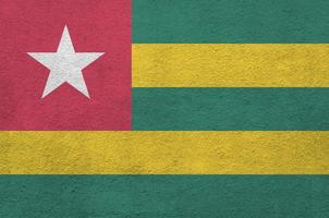 Togo-Flagge in hellen Farben auf alter Reliefputzwand dargestellt. strukturierte Fahne auf rauem Hintergrund foto