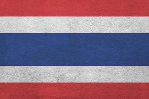 thailand-flagge in hellen farben auf alter reliefputzwand dargestellt. strukturierte Fahne auf rauem Hintergrund foto