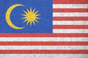 malaysia-flagge in hellen farben auf alter reliefputzwand dargestellt. strukturierte Fahne auf rauem Hintergrund foto