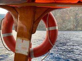 rote Rettungsboje vor dem blauen Meer und dem weißen Schiff foto