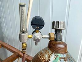 Druckminderer und Manometer zum Messen des Drucks an einer eisernen Industriegasflasche in einer Fabrik foto