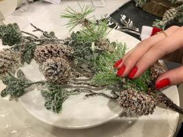 Weihnachtstischdekoration. Fichtenzweig mit Cranberry mit Schnee bestäubt. Feiertage Hintergrund. Dekorationen foto