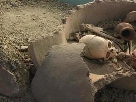 Archäologische Ausgrabungen. Menschliche Überreste Skelettknochen, Schädel im Erdgrab. echter Baggerprozess. im freien, kopierraum, nahaufnahme foto
