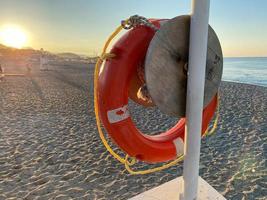 runde, nicht sinkende rote Rettungsboje zur Sicherheit, um das Leben von Ertrinkenden zu retten Touristen am Strand in einem warmen östlichen tropischen Land Southern Paradise Resort foto