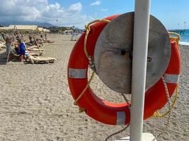 runde, nicht sinkende rote Rettungsboje zur Sicherheit, um das Leben von Ertrinkenden zu retten Touristen am Strand in einem warmen östlichen tropischen Land Southern Paradise Resort foto