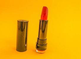 leuchtend glänzender Lippenstift in einer schwarzen Tube. schöner sexy roter Farbton. modischer Lippenstift in kompakter Verpackung. Lippenvergrößerung mit Lippenstift foto
