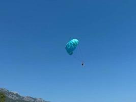 Gleitschirmfliegen. Gleitschirmlandung auf blauem Meeresgrund foto