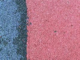blau-rosa Textur, Steine in verschiedenen Farben. ein Hintergrund aus kleinen, rosa und blauen Steinen, die dicht an dicht auf der Straße liegen. Sportböden, rutschfeste Böden foto