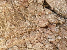 hintergrund und textur von bergschichten und rissen im sedimentgestein an der felswand. Stein Textur Nahaufnahme Hintergrund foto