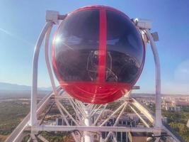 runde Kabine in roter Farbe zum Fahren auf einem Karussell. Stadtrundfahrt mit dem Riesenrad. sichere und zuverlässige Kabine aus Metall mit langlebigem, undurchdringlichem Glas foto