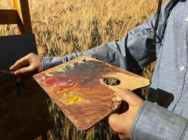 Nahaufnahme eines männlichen Malers mit Pinsel und Malerei foto