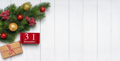 neujahrshintergrund mit geschmücktem tannenbaum und rotem ewigem kalender und geschenkbox foto