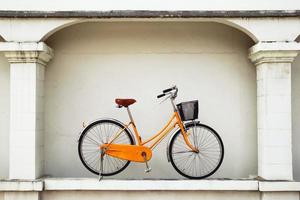 Fahrrad auf dem Hintergrund einer gestrichenen weißen Wand auf einer Straße. foto