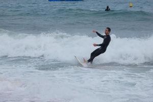 Surfer, die Wellen in einem sturmgepeitschten Meer reiten foto