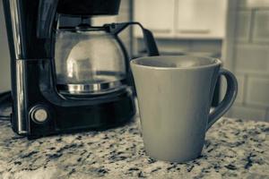 Kaffeemaschine und rote Tasse auf dem Tisch in der Küche. foto