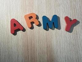 Foto des Alphabets auf einem Holztisch, auf dem Armee steht.