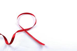 rotes Stützband isoliert auf weißem Hintergrund. welt-aids-tag und nationaler hiv-aids- und alterungsbewusstseinsmonat mit roter schleife. Copyspace-Bereich foto