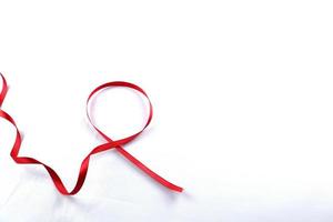 rotes Stützband isoliert auf weißem Hintergrund. welt-aids-tag und nationaler hiv-aids- und alterungsbewusstseinsmonat mit roter schleife. Copyspace-Bereich foto