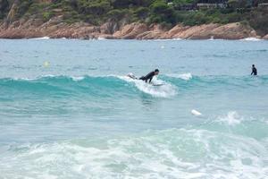 Surfer, die Wellen in einem sturmgepeitschten Meer reiten foto