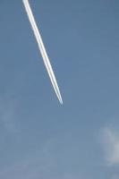 weiße Spur eines Flugzeugs unter dem blauen Himmel foto