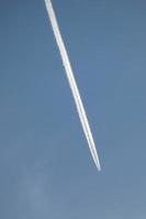 weiße Spur eines Flugzeugs unter dem blauen Himmel foto