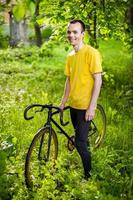 Ein junger Mann hielt mit seinem Fahrrad in einem öffentlichen Park an, um sich auszuruhen. foto